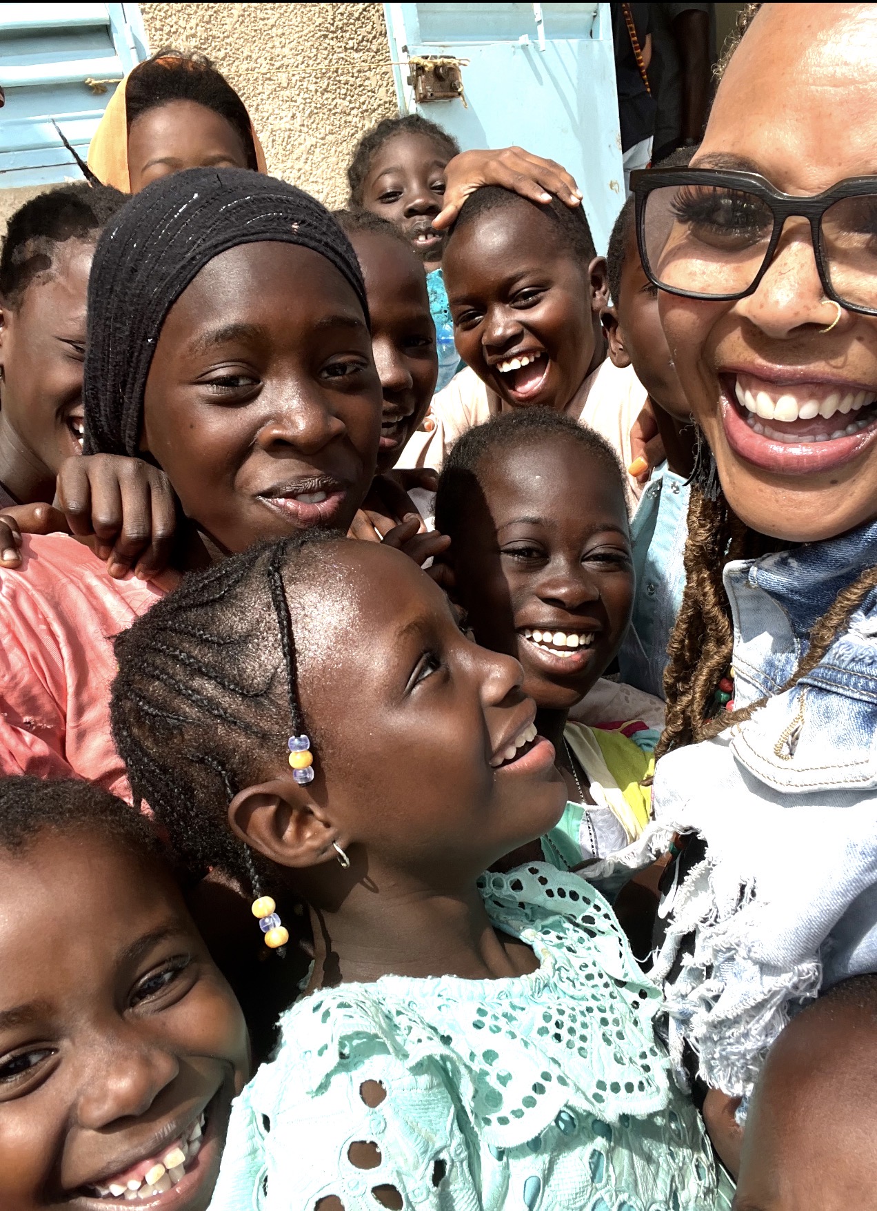 Dr. Renetta Weaver smiling with a group of children in Senegal, West Africa.